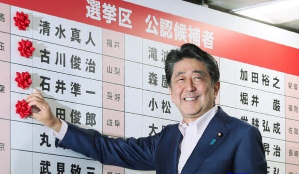 安倍往墙上贴代表当选的花