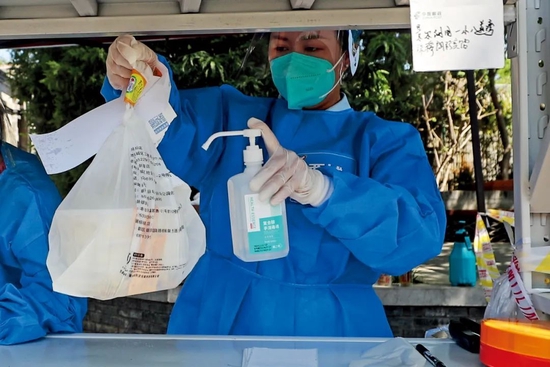 社区志愿者接收物品后对外包装进行消杀