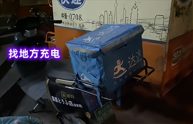 一名外卖小哥竟盖着被子和送外卖时穿的冲锋衣，睡在自己的电动车上