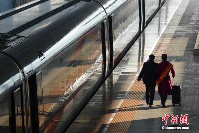 乘务员在重庆北站站台帮助老人乘车