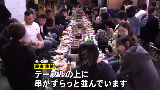 露天的广场上摆了无数张桌子，挤满了八方来客，场面热闹得很.jpg