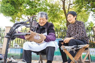 市民在江苏省南通市海安高新区人民西路一摊点修鞋