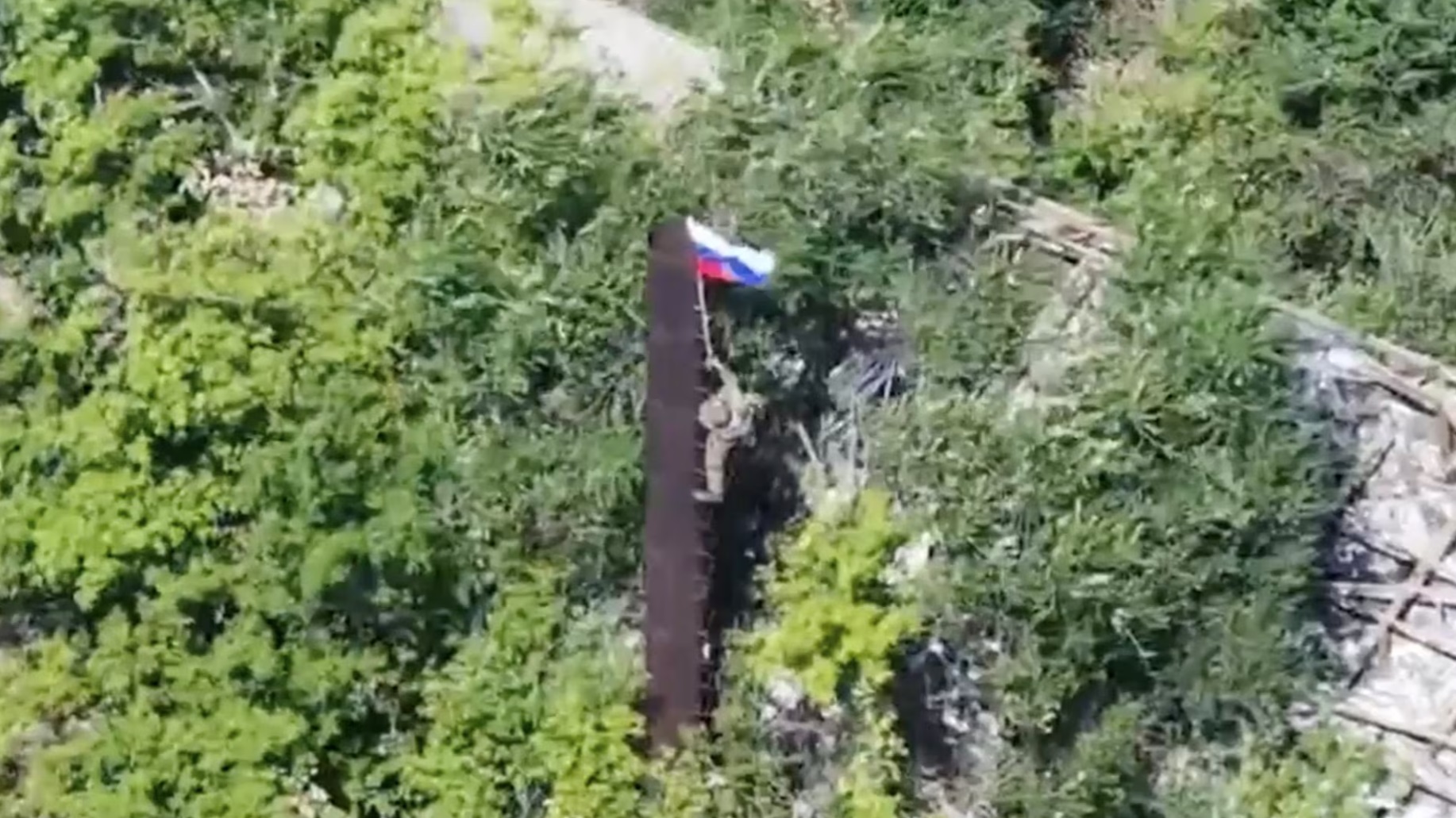 一名俄罗斯士兵在俄乌军事冲突中占领顿涅茨克地区的乌克兰亚布卢尼夫卡（Yablonovka）定居点后升起了一面旗 ...