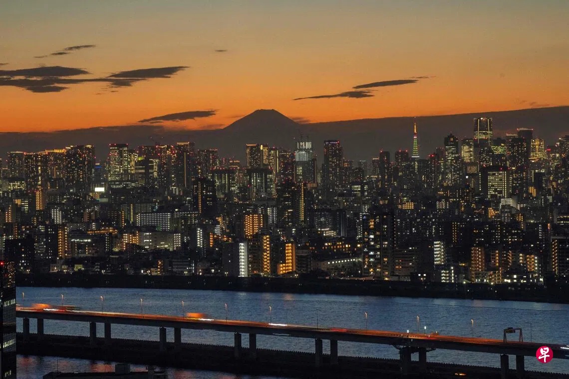 日本东京市中心在黄昏下的城市地平线，远处可见日本最高峰富士山