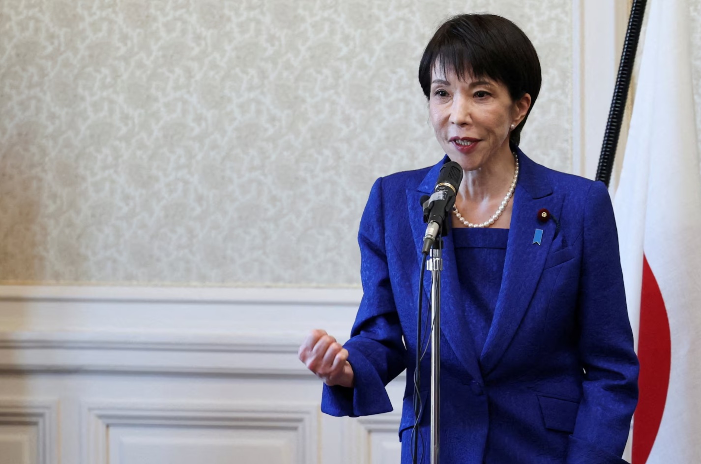 日本首相兼执政党自民党总裁高市早苗在自民党议员会议上发表讲话时握紧拳头 ...